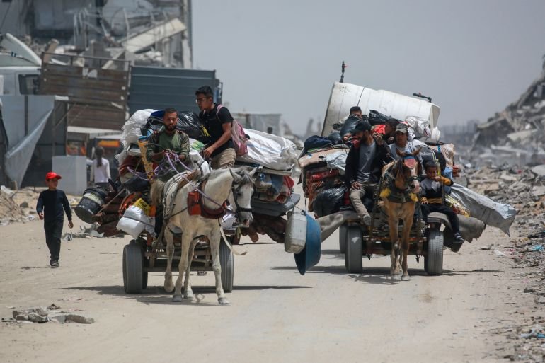 Palestinians move with their belongings as they flee the northern cities of Jabalia and Beit Lahia Gaza Strip towards Gaza City amid continuous Israeli strikes in the besieged Palestinian territory on May 17, 2025. (Photo by Bashar TALEB / AFP)