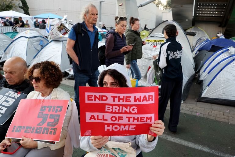 People holds placards as friends and relatives of Israelis held hostage by Palestinian militants in Gaza since October 2023, set up tents around the Defence Ministry in Tel Aviv calling for action to secure their release on March 11, 2025. (Photo by Jack GUEZ / AFP)