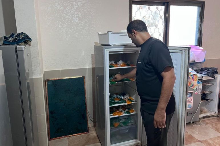 المجدلاوي أثناء عمله في تعبئة ثلاجته بأكياس البراد لتبريدها (نيوز عربي)