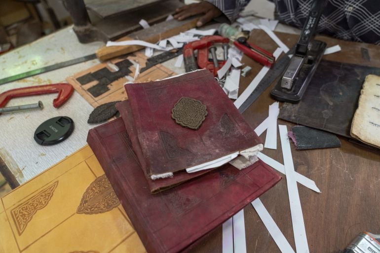 A book cover being restored at Sherif’s museum workshop [Jaclynn Ashly/Al Jazeera]