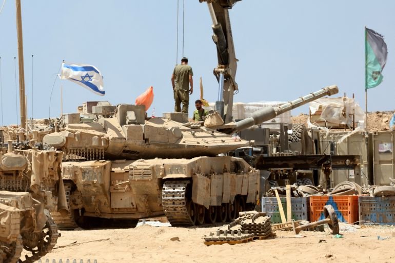Israeli troops deploy with their tanks near the border fence with the Gaza Strip on August 1, 2025. (Photo by Jack GUEZ / AFP)