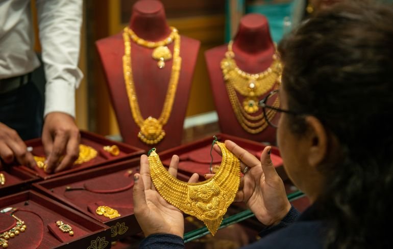 New Delhi, India- November 12 2020: woman holding gold neckless during gold shopping, golden necklace set for sale at a store while gold price is high all time.