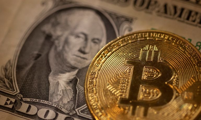 A representation of virtual cryptocurrency Bitcoin is placed on a U.S. Dollar banknote in this illustration taken November 28, 2021. REUTERS/Dado Ruvic/Illustration 2021-11-28T234405Z_20920831_RC2W3R98MYKO_RTRMADP_3_FINTECH-CRYPTOCURRENCY