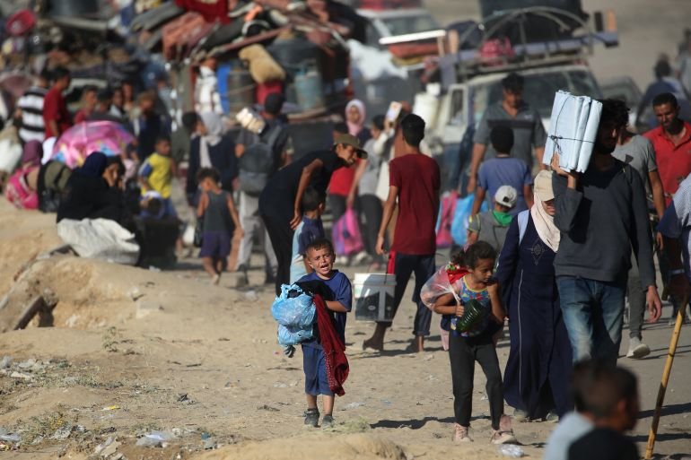 Displaced Palestinians move with their belongings southwards on a road in the Nuseirat refugee camp area in the central Gaza Strip following renewed Israeli evacuation orders for Gaza City on September 16, 2025.