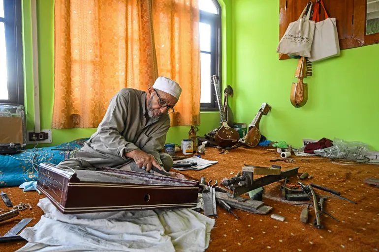 In this photograph taken on September 23, 2025, artisan Ghulam Mohammad Zaz makes the Santoor instrument at his home in Srinagar.