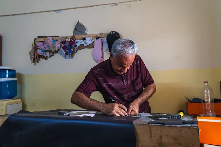 Saad Abdul Aal’s hands remain quick and precise after more than four decades of shoemaking. [Aram Hakim/IOM]