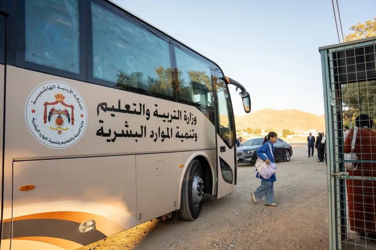 طالبة بالمرحلة الثانوية تنزل من حافلة مخصصة لنقل طلاب المدارس الحكومية مجاناً جنوب الأردن