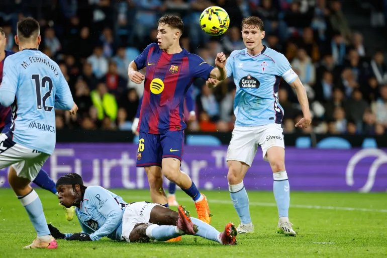 Celta's Ilaix Moriba, bottom, blocks a shot on goal by Barcelona's Fermin Lopez during the Spanish La Liga soccer match between Celta Vigo and Barcelona in Vigo, Spain, Sunday, Nov. 9, 2025. (AP Photo/Lalo R. Villar)