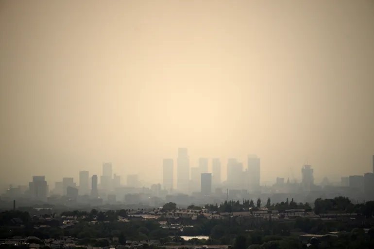 OLDHAM, ENGLAND - JULY 13: Seen from Oldham, a veil of smoke from the Peak District wildfires hangs over the Manchester City skyline on July 13, 2026 in Oldham, England. A major incident has been declared on between Tintwistle Moor in Glossop, Derbyshire and Dovecote Reservoir as high winds and a severe heatwave caused a wildfire, which originally broke out on 24 June, to flare up. (Photo by Christopher Furlong/Getty Images)