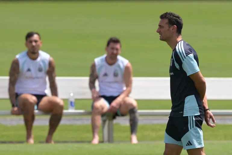 (FILES) Argentina's head coach Lionel Scaloni (R) walks as Argentina's forward #10 Lionel Messi (C) and Argentina's midfielder #05 Leandro Paredes (L) sit during a training session at the Atlanta United Training Centre in Marietta, Georgia, on July 16, 2026, ahead of the 2026 World Cup football tournament final match between Spain and Argentina.