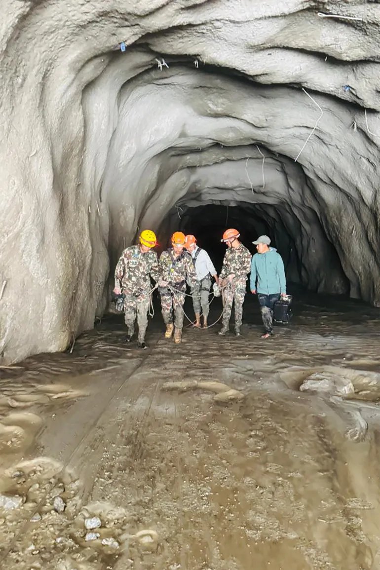 This handout photograph taken and released by Nepal's Prime Minister Secretariat on August 31, 2026 shows Nepali soldiers walking inside a tunnel to rescue workers after flash floods at Rasuwagadhi Hydropower Project in Rasuwa district.