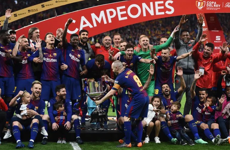 أندريس إنييستا يحمل كأس ملك إسبانيا إلى جانب ليونيل ميسي بعد فوز برشلونة على إشبيلية بخماسية نظيفة في نهائي 2018 (غيتي)