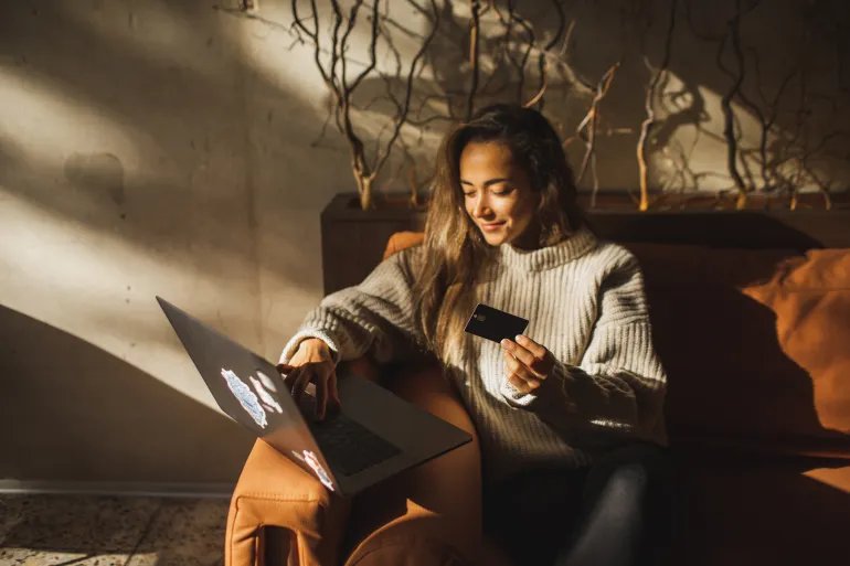 Young hispanic woman using computer and credit card to manage online banking. Pretty girl shopping online. Online shopping makes life easier. Convenient contactless payment. Making payment online in internet.