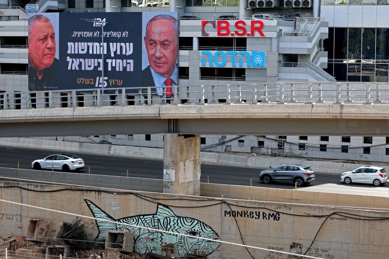 Cars drive past an advertisement featuring Israel's Prime Minister Benjamin Netanyahu (R) of the Likud party and country's former chief of the general staff and leader of the Yashar centrist political party Gadi Eisenkot, along a street in Ramat Gan on September 23, 2026.
