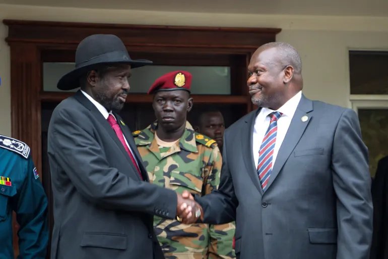 FILE - South Sudan's president Salva Kiir, left, and vice-president Riek Machar, right, shake hands after meetings in Juba, South Sudan, on Oct. 20, 2019, to discuss outstanding issues to the peace deal. (AP Photo/Sam Mednick, File)
