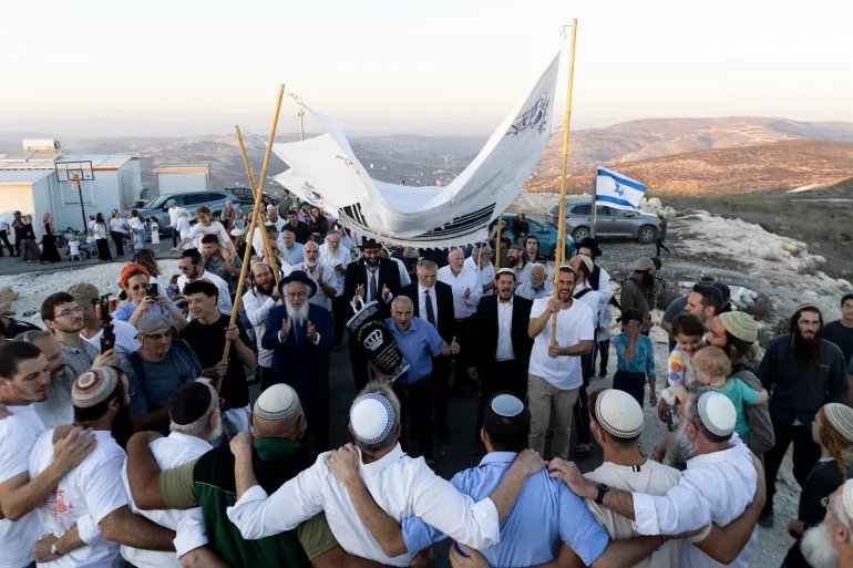 HOMESH, WEST BANK - SEPTEMBER 16: Israeli settlers celebrate with Torah scroll as a new synagogue is opened in the Israeli settlement of Homesh in the occupied West Bank. The settlement was reestablished in 2025 with Israeli government approval after having been demolished in 2005. The expansion of Israeli settlements in the West Bank, considered illegal under international law, has drawn renewed international scrutiny, including the British government's recently announced ban on goods imported from the occupied West Bank. (Photo by Amir Levy/Getty Images)
