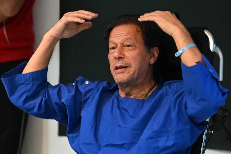 (FILES) In this picture taken on on November 4, 2022, Pakistan's former prime minister Imran Khan addresses the media representatives at a hospital in Lahore, a day after an assassination attempt on him.