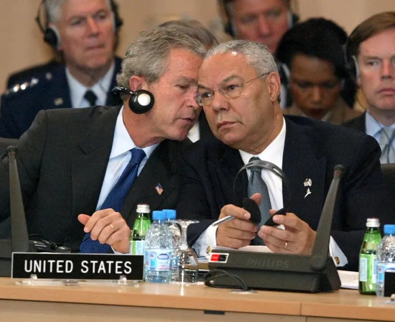 U.S. President George W. Bush, left, has a word with Secretary of State Colin Powell during opening remarks at the NATO summit in Istanbul, Turkey, Monday, June 28, 2004. (AP Photo/Charles Dharapak)