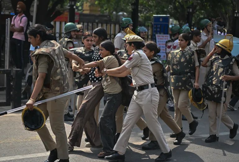 NEW DELHI, INDIA - OCTOBER 10: Police officers detain a protester during a anti-government rally on October 10, 2026 in New Delhi, India. The Cockroach Janta Party (CJP) has called a mass protest to demand the resignation of India's Chief Election Commissioner, Gyanesh Kumar, over what they say are alleged irregularities in electoral processes and the revision of voter rolls. (Photo by Ritesh Shukla/Getty Images)