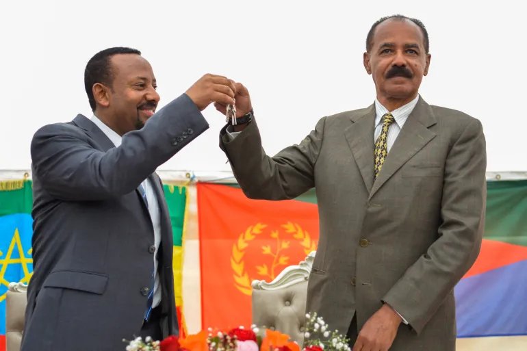 (FILES) Ethiopian Prime Minister Abiy Ahmed (L) and Eritrean President Isaias Afwerki (R) celebrate the opening of the Embassy of Eritrea in Ethiopia reopened following the official visit after twenty years, in Addis Ababa on July 16, 2018.