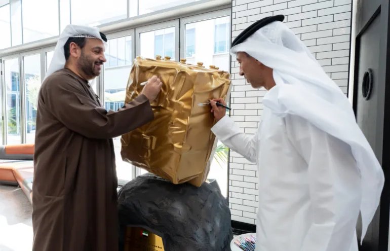 Faisal Al Bannai, secretary-general of the Advanced Technology Research Council, and Ahmad Belhoul Al Falasi (left), chairman of the UAE Space Agency, sign a model of the lander that will fly on the Emirates Mission to the Asteroid Belt, which is scheduled to launch in March 2028. (Image credit: TII)
