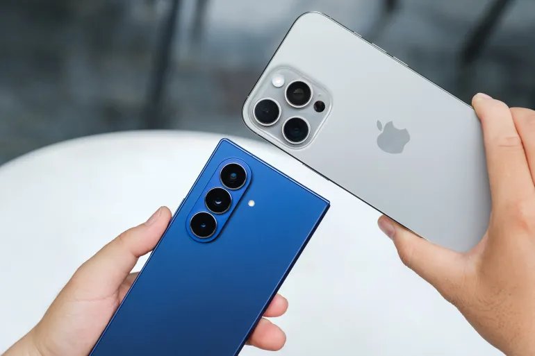 HO CHI MINH CITY, VIETNAM – AUGUST 5 2025: Samsung Galaxy Z Fold7 and Apple iPhone 16 Pro Max shown side by side, highlighting foldable inner display and periscope zoom camera module