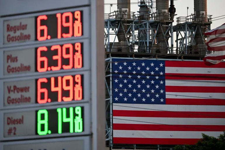 (FILES) Gas prices at a Shell gas station above a gallon for regular gasoline and a gallon for diesel are displayed across from a US flag outside of the Marathon Petroleum Corp. Los Angeles Refinery in Carson, California on September 22, 2026.